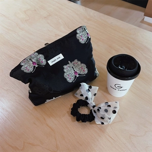 Detail of floral butterfly brocade makeup bag with a polka dot bow scrunchie set