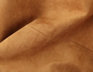 Nahaufnahme von braunem Wildlederstoff mit hochwertigen Nähten an Jacken- und Shorts-Set