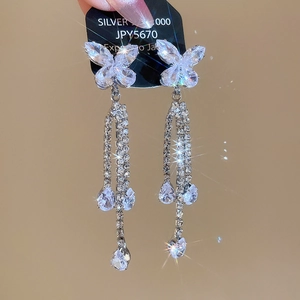Macro shot of silver butterfly tassel earrings with sparkling zircon crystals and long chains