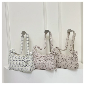 Detailed view of floral canvas hobo bags with pleated straps and bow tie accents