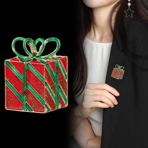 Christmas gift box brooch with red enamel green bow and gold glitter on black suit