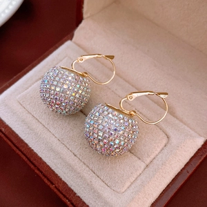 Detailed close-up of golden hoop earrings featuring vibrant multicolor crystal pave spheres