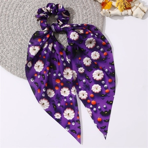 Détail de l'élastique à cheveux violet Halloween avec motifs citrouilles et ruban en soie