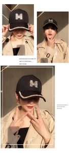 Detail of black baseball cap featuring rhinestone M logo and sparkling brim decoration