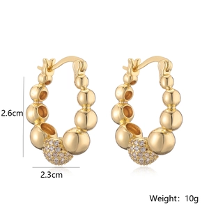 Detail view of gold beaded hoop earrings with zircon pendant and size measurements