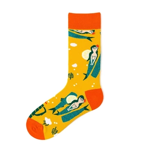 Detail of yellow cotton socks featuring green-tailed mermaid and lemon illustration