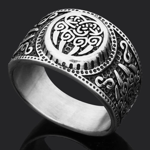 Close-up of vintage Viking Mjolnir ring with intricate Nordic rune engravings on metal