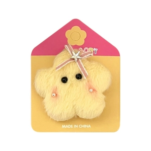 Cute yellow plush star hair clip with pink bow and silver star detail on a card