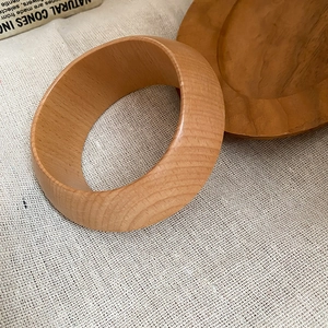 Détail macro du grain de bois naturel sur un bracelet jonc minimaliste en bois rétro