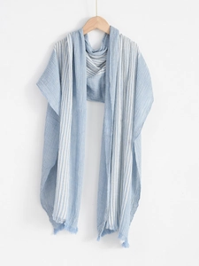 Detail of blue and white striped cotton-linen scarf with fringed edges on wooden hanger