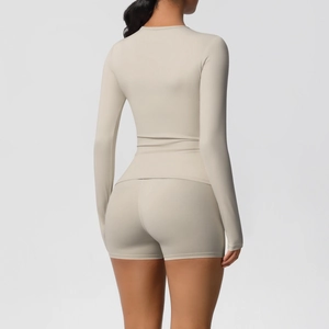 Rear view of beige slim fit yoga set featuring long sleeve top and athletic shorts