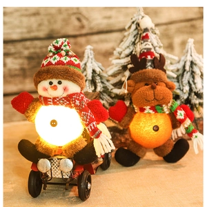 Close-up of plush LED snowman on vintage car with deer and holiday tree background