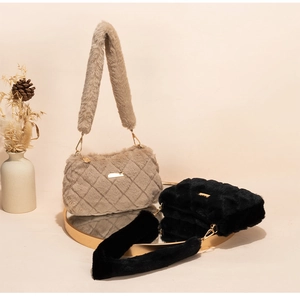 Close-up of khaki and black plush shoulder bags with quilted patterns and metal chains