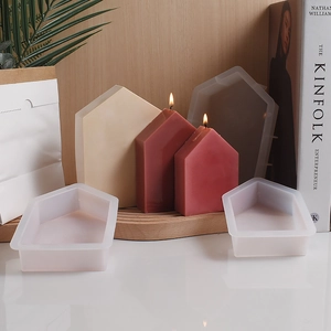 Detail of house-shaped silicone molds with finished scented candles and soft lighting