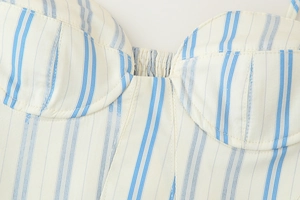 Detailed macro view of cream cotton fabric with blue stripes and elastic pleated chest design