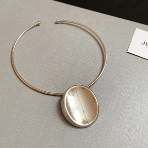 Detailed view of silver choker featuring a large polished oval pendant with mirror finish