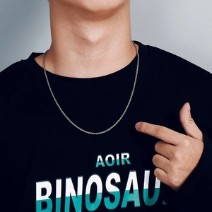 Detail view of silver stainless steel cuban link chain necklace worn on male model neck