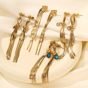 Detailed macro view of luxury gold tassel earrings featuring blue teardrop gemstone accents