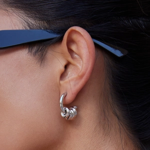 Detail shot of multi-link silver hoop earrings worn by a model for a modern look