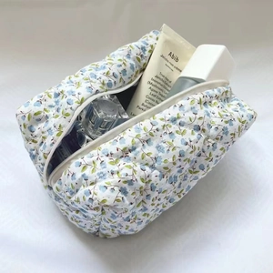 Inside view of a large capacity quilted floral makeup bag with blue flower patterns