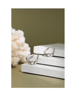 Dettaglio macro di orecchini a cerchio in argento sterling S925 con design a spirale