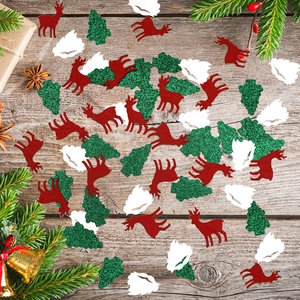 Christmas confetti with reindeer and snowflakes on wooden background with holiday decor