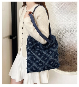 Detail of star pattern and frayed edge diamond quilting on navy denim tote bag