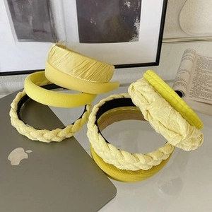 Detail of yellow fabric headbands with woven and pleated textures on an office desk
