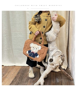 Detail of warm brown quilted children's shoulder bag featuring a cute teddy bear patch