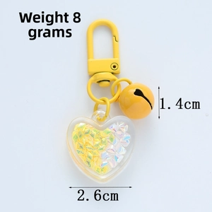 Detail view of a yellow heart keychain featuring a 2.6cm acrylic charm with colorful sequins
