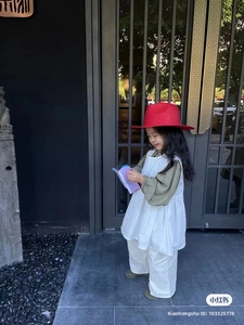 Dettaglio di un cappello di paglia rosso per bambini, parte di un outfit estivo vintage