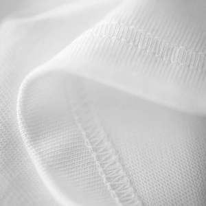 Macro view of high-density knit fabric and reinforced double-stitched seams on white T-shirt