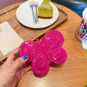 Détail du mini sac papillon rose vif avec chaîne dorée dans un décor de style de vie