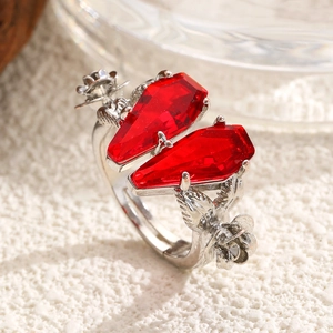 Close-up of gothic adjustable ring featuring red coffin-shaped stones and floral carvings