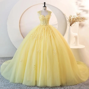 Detail of yellow ball gown evening dress with heavy embroidery lace and tulle on a mannequin
