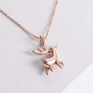 Elegant rose gold stainless steel deer pendant necklace on a clean white stone background