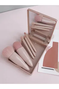 Close-up of portable 5-piece pink makeup brush set in a compact case with mirror