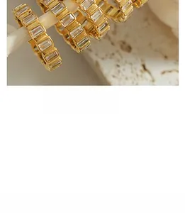 Vue macro détaillée de boucles d'oreilles en C plaquées or 18K avec zircons baguette