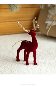 Close-up of burgundy flocked Christmas reindeer with golden antlers on snow decor
