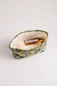 Detailed interior view of floral embroidery makeup bag with cosmetics and satin lining
