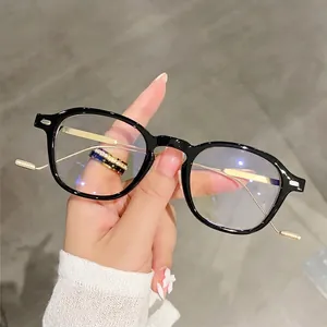Classic black round-frame glasses with golden metal temples and clear blue light lenses