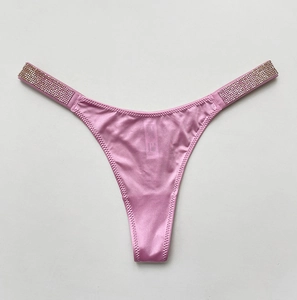 Close-up of pink satin thong with sparkly rhinestone side straps for fitness style