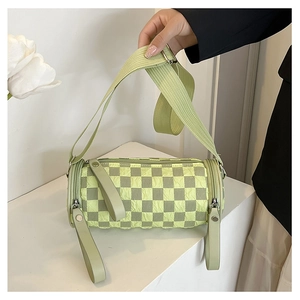 Close-up of a green checkerboard barrel bag featuring a unique bubble fabric texture
