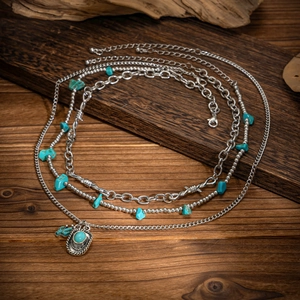 Detail of bohemian layered necklace with turquoise beads and western cowboy hat pendant