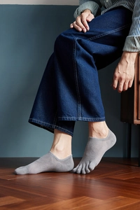 Detail of grey men's five-finger low cut socks showing breathable mesh and split toe design