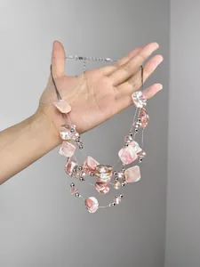 Detail of multilayer pink shell necklace with irregular baroque fragments and metallic beads