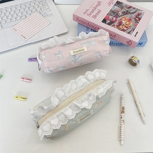 Cute lace-edged cat print pencil bags in pastel pink and green colors on a desk