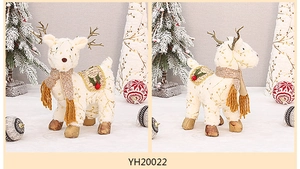 Dettaglio statuetta renna peluche di Natale, con simpatico cervo con sciarpa in scena di neve.