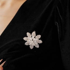 Macro shot of sparkling snowflake brooch with high-quality cubic zirconia on velvet