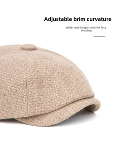 Detail showing the foldable wide brim of the beige tweed newsboy cap for face framing